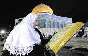 Una mujer lee el Corán en la ciudad vieja de Jerusalén, uno de los lugares santos para el Islam. :: AMMAR AWAD/REUTERS