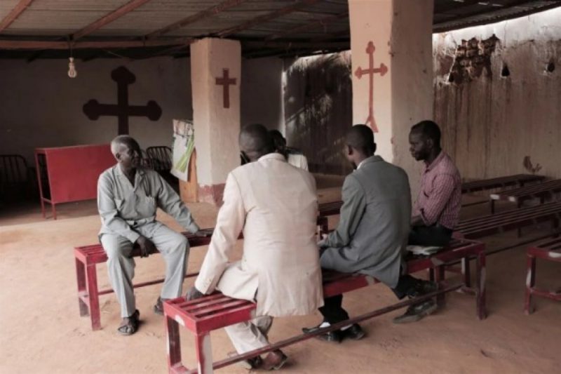 Lutheran reverend Yousef Zamgila (L) speaks to members of his congregation at the small improvised church they helped set up in a neighbours yard in Omdurman, Khartoums twin city, on August 22, 2019. Sudan's Christians suffered decades of persecution under the regime of Islamist general Omar al-Bashir. | JEAN MARC MOJON