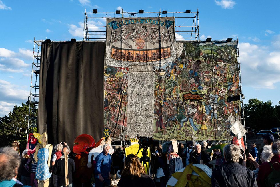 Mural del colectivo indonesio Taring Padi titulado 'La justicia del pueblo' mientras personal de la exposición de arte contemporáneo Documenta lo cubre con una lona negra en Kassel, Alemania. Swen Pfortner