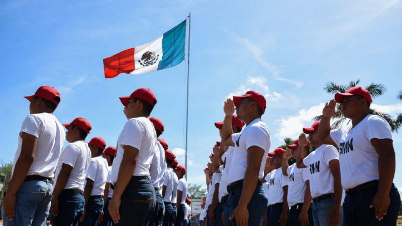 Militares en formación ante la bandera de México