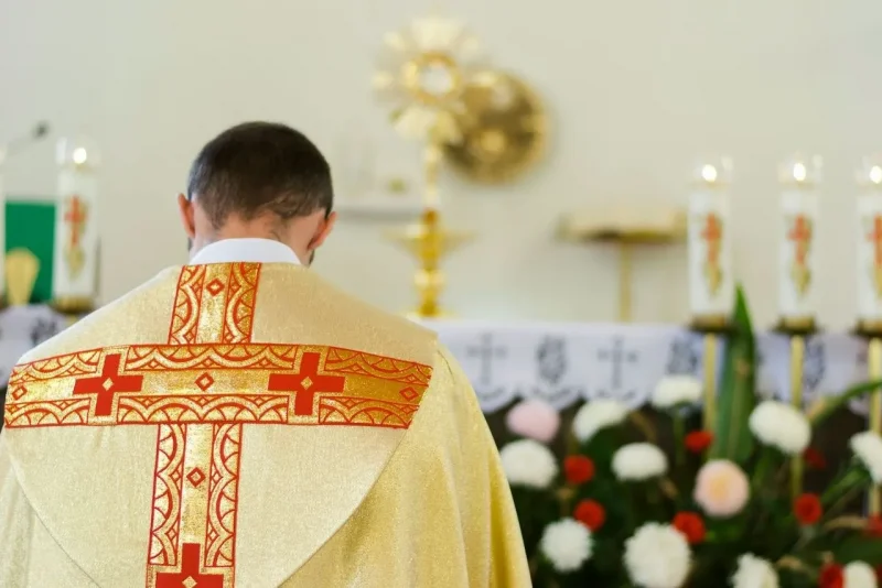 Sacerdote católico de espaldas oficiando misa