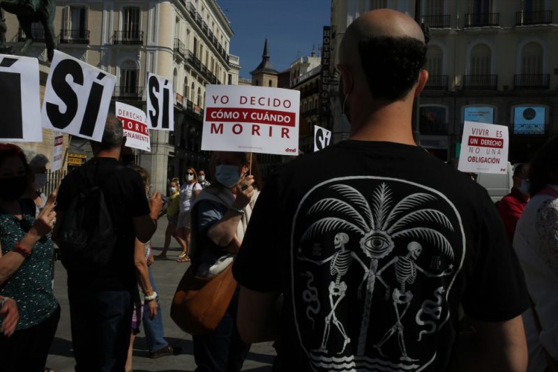 Un grupo de personas se reúne sosteniendo pancartas y carteles durante la concentración de la asociación Derecho a Morir Dignamente (DMD) en la Puerta del Sol, a 25 de junio de 2021, en Madrid, (España).