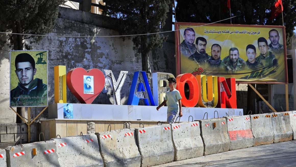 Un joven camina junto a retratos de líderes de Hizbulá en la localidad libanesa de Yaroun. Mohammad Zaatari / AP