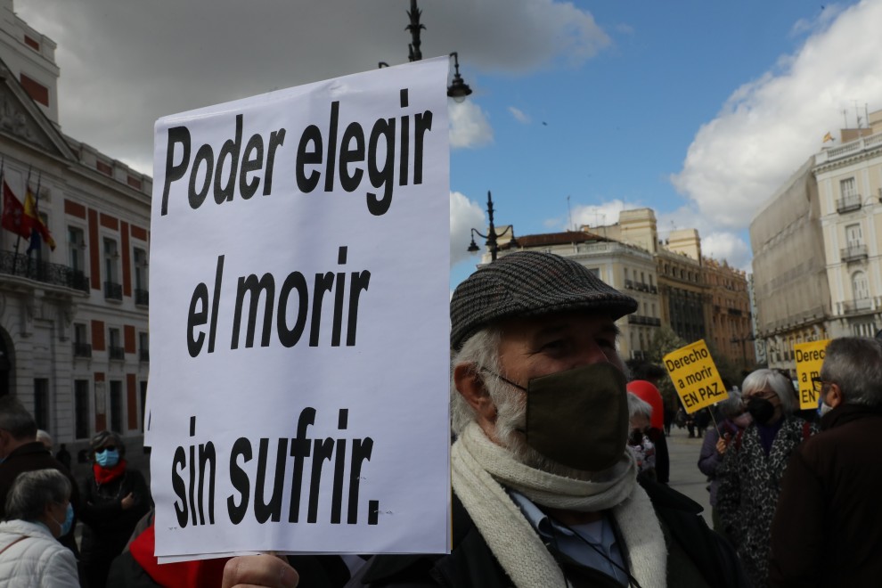 Un hombre con un cartel en el que se lee: `Poder elegir el morir sin sufrir´ durante una concentración de Derecho a Morir Dignamente en la Puerta del Sol, en Madrid (España), a 18 de marzo de 2021.