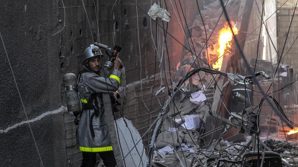 Un bombero palestino trabaja en el lugar de un edificio destruido tras los ataques israelíes.EFE/EPA/MOHAMMED SABER