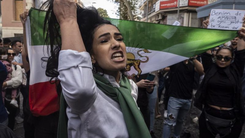 Una mujer muestra su cabello mientras unas personas sostienen una bandera de Irán anterior a la Revolución Islámica durante una protesta frente al Consulado iraní en Estambul en protesta por la muerte de Mahsa Amini. EFE/EPA/ERDEM SAHIN