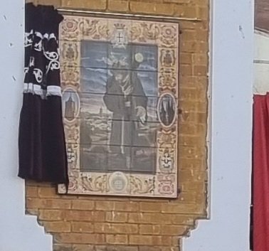 Azulejo conmemorativo, en el Edificio Antiguas Escuelas El Jardín, de la concesión de la medalla de oro de zalamea la real a la imagen de Jesús Nazareno