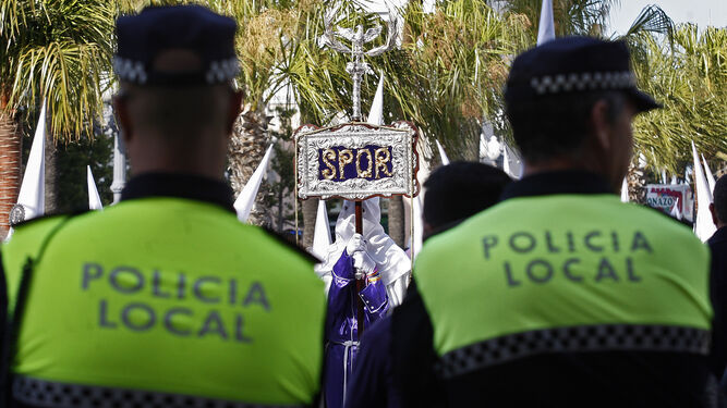 Dos agentes de la Policía Local ante un cortejo procesional en Cádiz. / J.P.