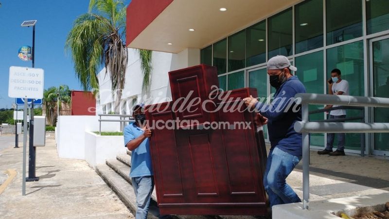 Dos hombres portan un mueble de la capilla del Hospital en Yucatán (México)