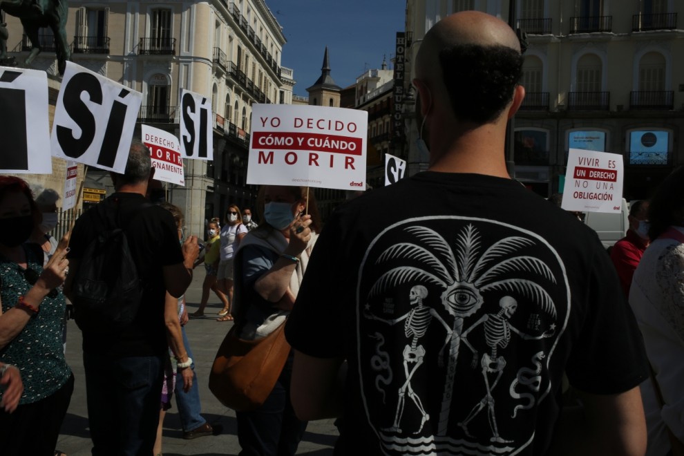 Un grupo de personas se reúne sosteniendo pancartas y carteles durante la concentración de la asociación Derecho a Morir Dignamente (DMD) en la Puerta del Sol, a 25 de junio de 2021. — Cézaro De Luca /
