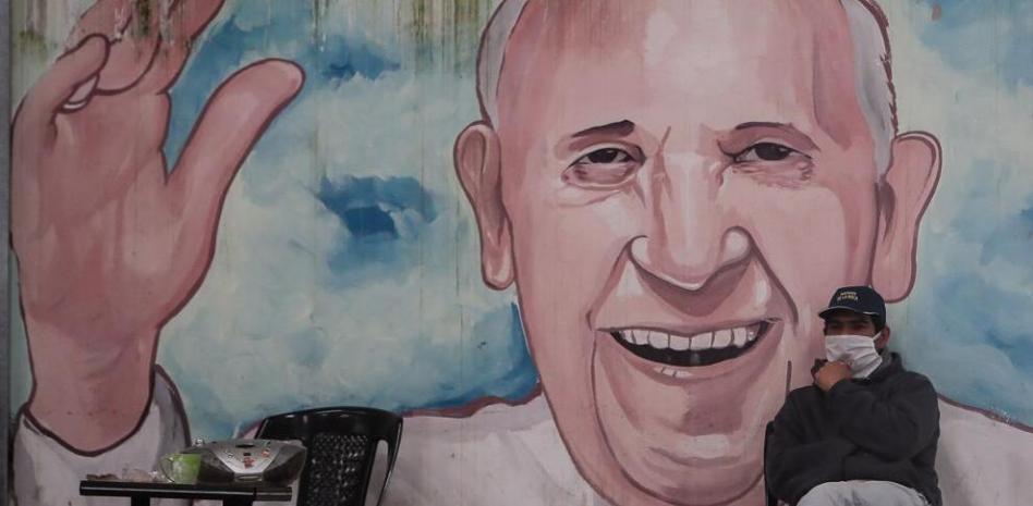 Una persona sin hogar espera junto a un mural con la imagen del papa Francisco en el barrio La Matanza de Buenos Aires (Argentina). Juan Ignacio Roncoroni