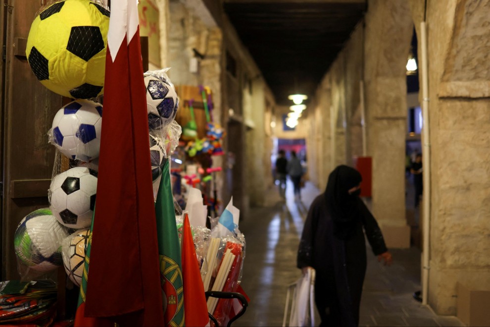 Una mujer camina, con el hiyab, por una calle de Catar decorada con banderas por el Mundial. — Amr Abdallah Dalsh / REUTERS