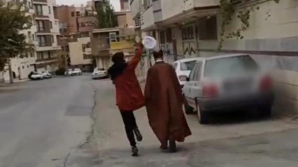 Una joven quitando el turbante a un clérigo en Irán.TWITTER