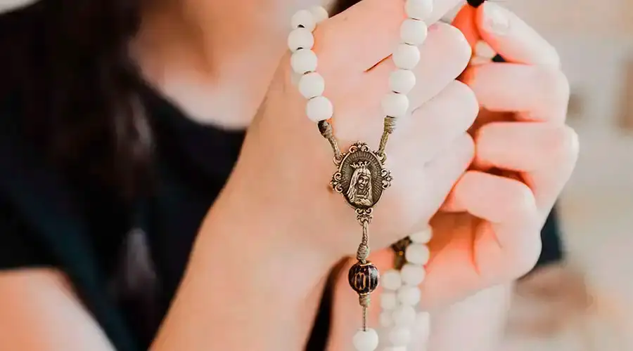 Imagen referencial de una mujer rezando con un rosario. Crédito: Unsplash