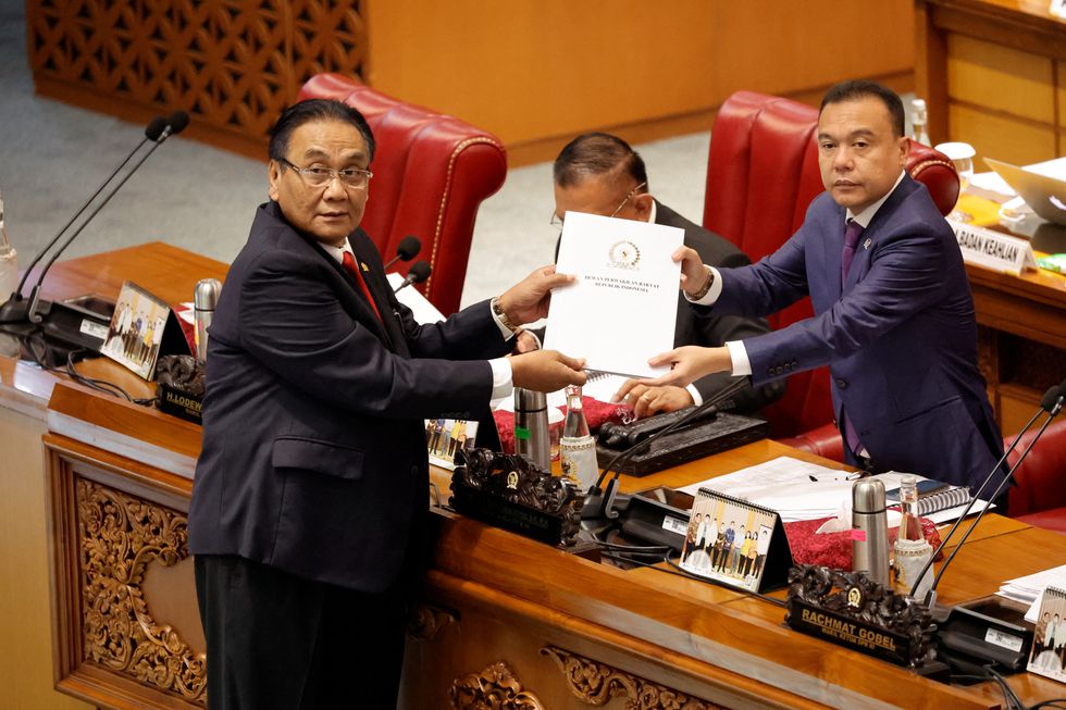 Dos parlamentarios indonesios muestran el informe sobre el nuevo código penal, durante una sesión plenaria parlamentaria celebrada este 6 de diciembre en Yakarta, Indonesia. Foto: WILLY KURNIAWAN
