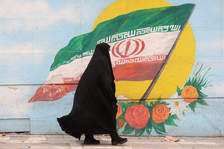 Una mujer camina junto a un mural que muestra la bandera de Irán, en Teherán, a 6 de diciembre de 2022. -Majid Asgaripour / WANA (West Asia News Agency) via REUTERS