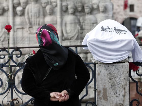 Una mujer deposita flores en la explanada de Sultanahmet, situada ante la mezquita azul en Estambul. (EFE / Sedat Suna)