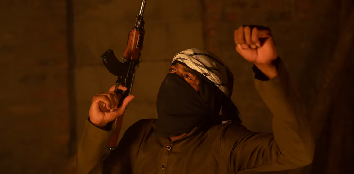 Un yihadista alzando un puño y un arma. Foto: Shutterstock / WESTOCK PRODUCTIONS