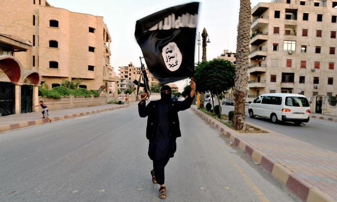 Un miembro del Estado Islámico ondea una bandera en Siria. /