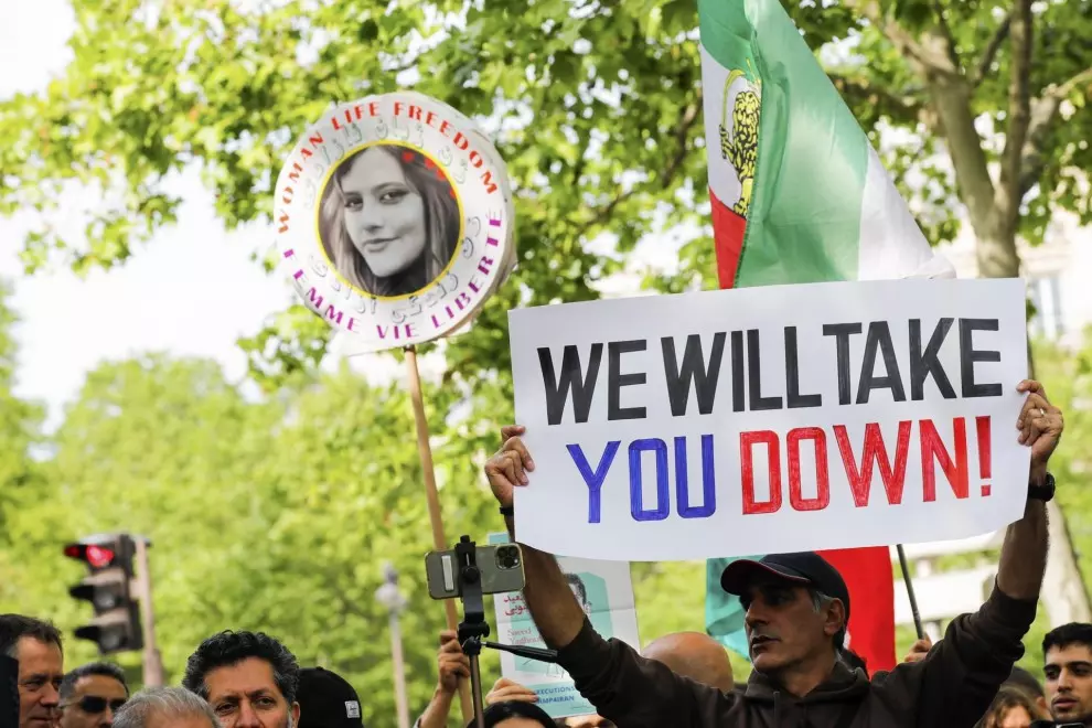 Manifestantes sostienen una pancarta y un retrato de Masha Amini, quien murió tras ser detenida por no llevar el velo islámico correctamente, en París, a 23 de mayor de 2023 . — Teresa Suárez / EFE