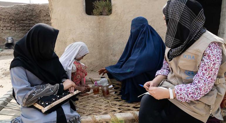 © UNOCHA/Charlotte Cans Un miembro del personal de la Oficina de Coordinación de Ayuda Humanitaria de la ONU habla con mujeres desplazadas en la provincia oriental de Nangahar, en Afganistán.