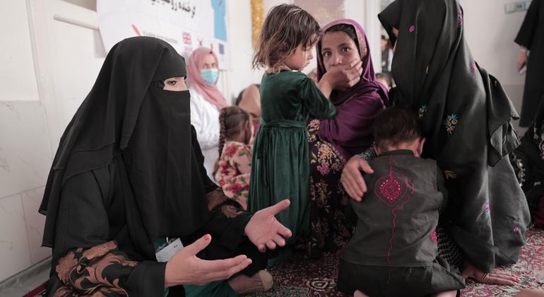 UNICEF/Christine Nesbitt Una asesora nutricional asesora a una madre y a sus hijos en una aldea afgana.