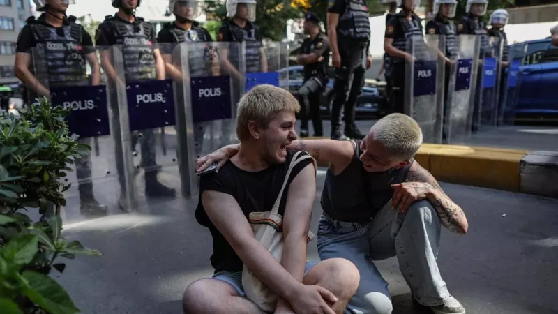 Dos miembros del colectivo LGTBI sentados frente a un cordón policial que trataba de evitar la celebración de la marcha del Orgullo en Estambul. EFE/EPA/Erdem Sahin