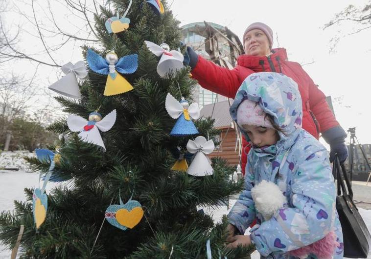 Una familia ucraniana decora el árbol de Navidad EFE