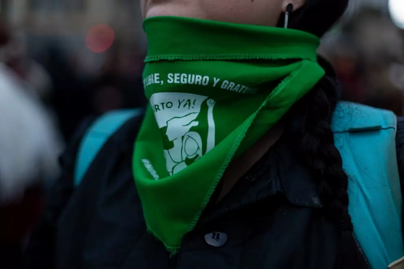 Una manifestante el 8M de 2022 en Barcelona con un pañuelo verde, símbolo de defensa de la legalización del aborto en Latinoamérica. — Sabine Greppo / Hans Lucas / AFP