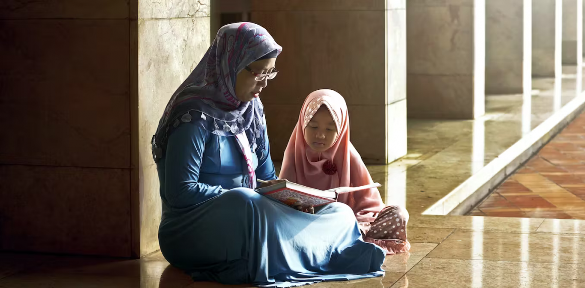 Una madre enseña a su hija leyendo el Corán en el interior de una mezquita en Indonesia. Leolintang/Shutterstock