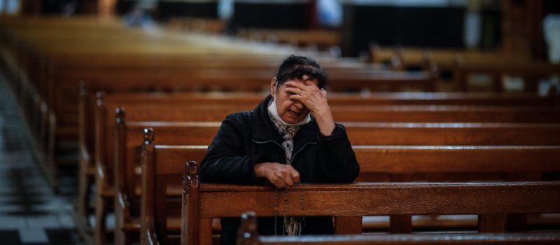 Una mujer reza sola en una iglesia durante la pandemiaEFE