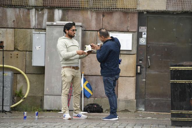 El refugiado iraquí Salwan Momika se dispone a prender fuego a un Corán frente al Parlamento sueco, este lunes en Estocolmo. / OSCAR OLSSON / EFE