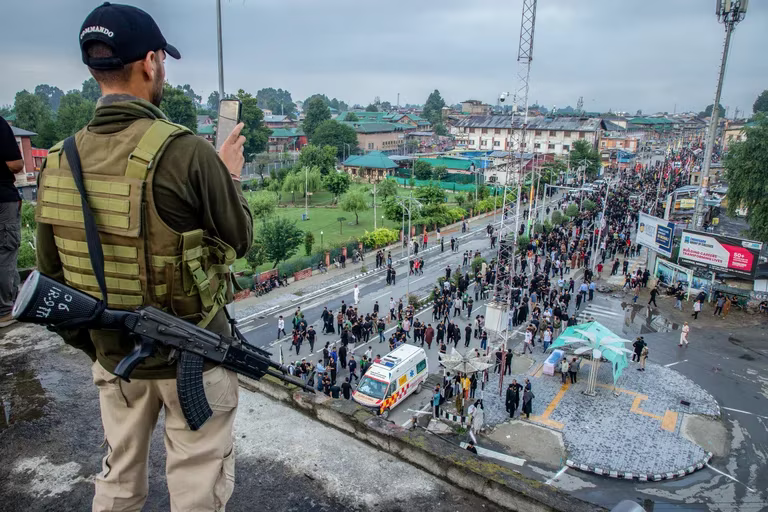 Militar indio filma con un móvil a una multitud desde una azotea