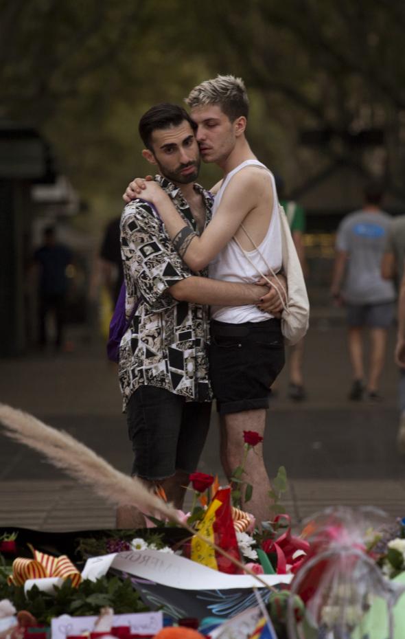 Unos jóvenes se abrazan ante el memorial de flores, mensajes y velas hecho en Las Ramblas de Barcelona tras el atentado, el 21 de agosto de 2017..Emilio Morenatti / AP