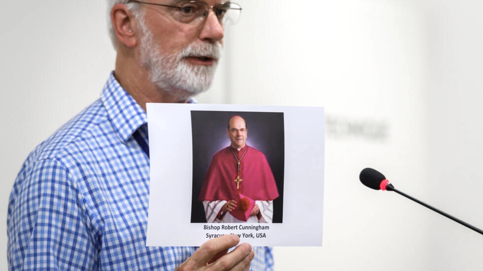 Un activista de una organización contra el abuso sexual de niños en la Iglesia católica muestra una fotografía de un clérigo durante una rueda de prensa en Ginebra el 7 de junio de 2018 © Fabrice Coffrini / AFP/Archivos