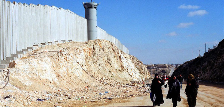 Mujeres palestinas caminando a lo largo del muro de separacón cerca de Ramalá, en Cisjordania. / ONU