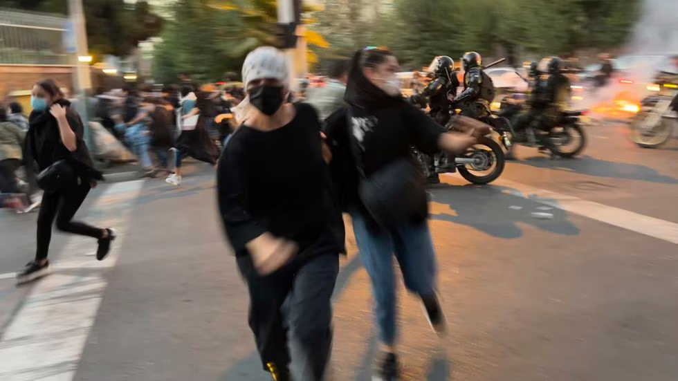 Dos mujeres huyen de la policía en una manifestación por la muerte de Mahsa Yina Amina, el 19 de septiembre de 2022 en Teherán.