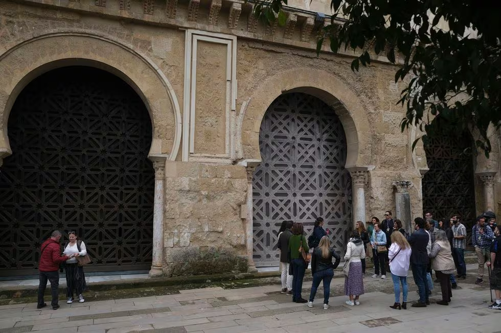 Un grupo de turistas junto a una guía a la entrada de la mezquita-catedral de Córdoba.PACO PUENTES