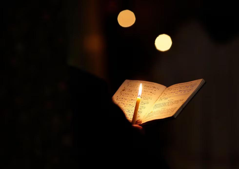 Un fraile franciscano sujeta una vela mientras reza y canta durante el rezo diario en una capilla.THOMAS COEX (AFP)