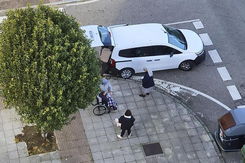 Religiosas colocando la papeleta en la mano de una señora en una silla de ruedas en Vigo.