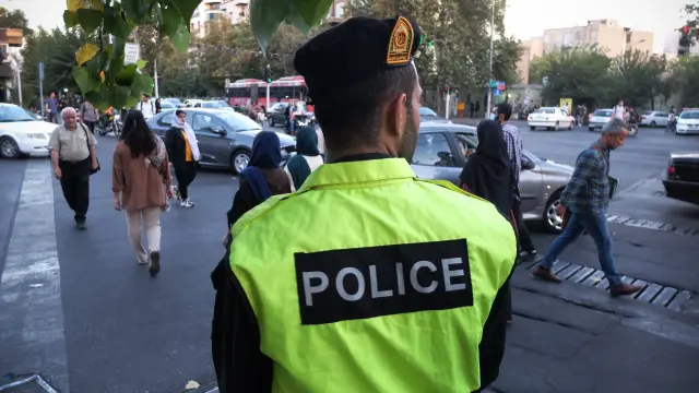 Un agente de la Policía observa a el paso de mujeres en Teherán.CONTACTO vía Europa Press
