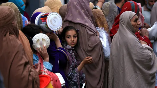 Mujeres con burka hacen cola para obtener comida durante el Ramadan en Peshawar, Pakistan.EFE/EPA/ARSHAD ARBAB
