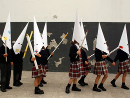 Unos niños, vestidos de penitentes, representan una procesión en un colegio de Sevilla, poco antes del inicio de las vacaciones de Semana Santa, en 2023.MARCELO DEL POZO (REUTERS)