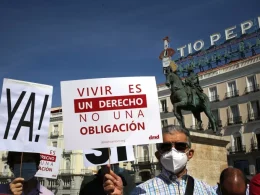 Un grupo de personas sostiene pancartas y carteles durante una concentración por la muerte digna en Madrid, a 25 de junio de 2021. — Cézaro De Luca / Europa Press