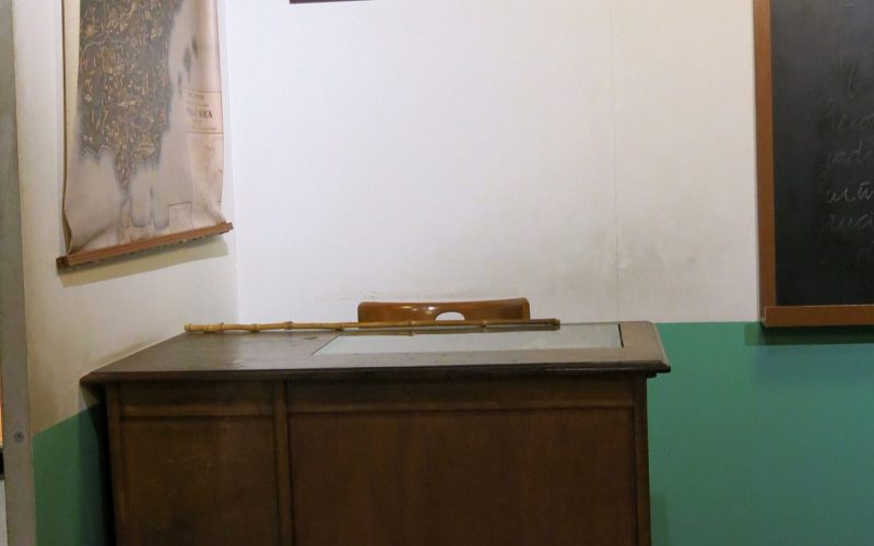 Recreación de un aula típica de una escuela durante el franquismo, presidida por un crucifijo y los retratos de Franco (a su derecha) y de José Antonio Primo de Rivera (a su izquierda). Museu d'Història de Catalunya. Foto: Wikipedia