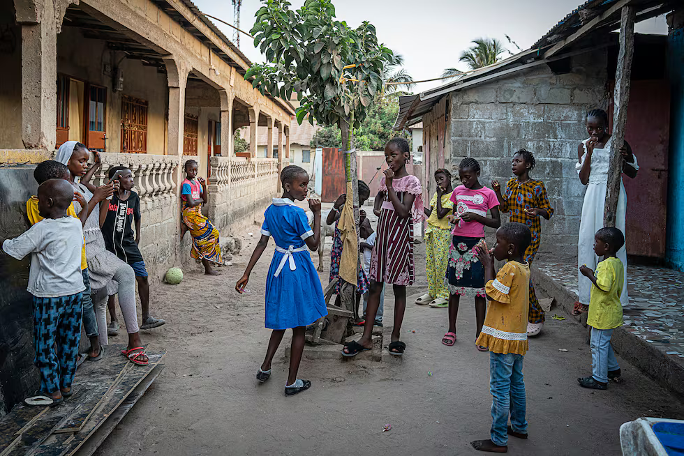 Un grupo de niñas jugando en el patio de su casa junto a amigos y vecinos en el pueblo de Brufut. Por edad, forman parte de la generación que ha crecido con el veto a la mutilación genital femenina.MARTA MOREIRAS