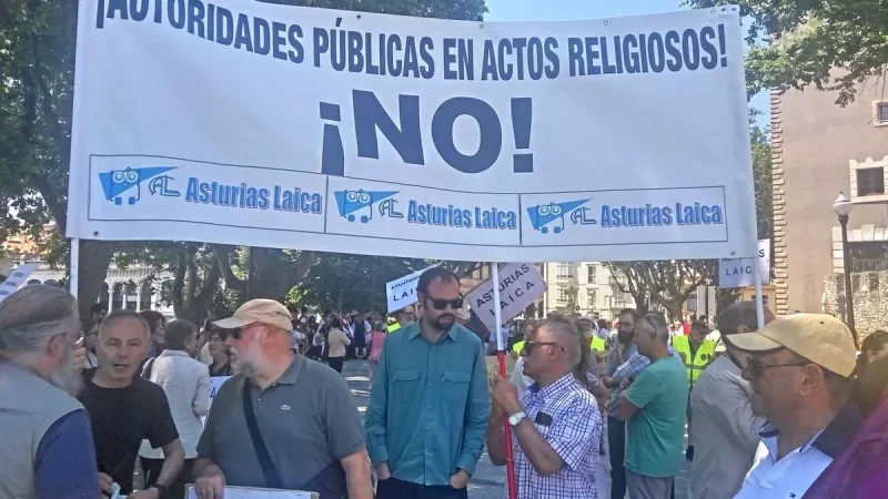 Miembros de Asturias Laica concentrados frente a la iglesia de San Pedro de Gijón, con José Luis Iglesias sosteniendo la pancarta Asturias Laica