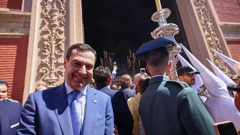 El presidente de la Junta de Andalucía, Juanma Moreno, espera la salida del paso de la Borriquita en la iglesia del Divino Salvador. / Joaquín Corchero / Europa Press