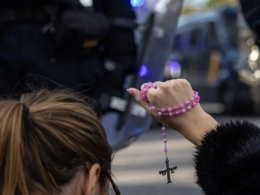 Una mujer con un rosario en las protestas contra el PSOE en la calle Ferraz. EFE