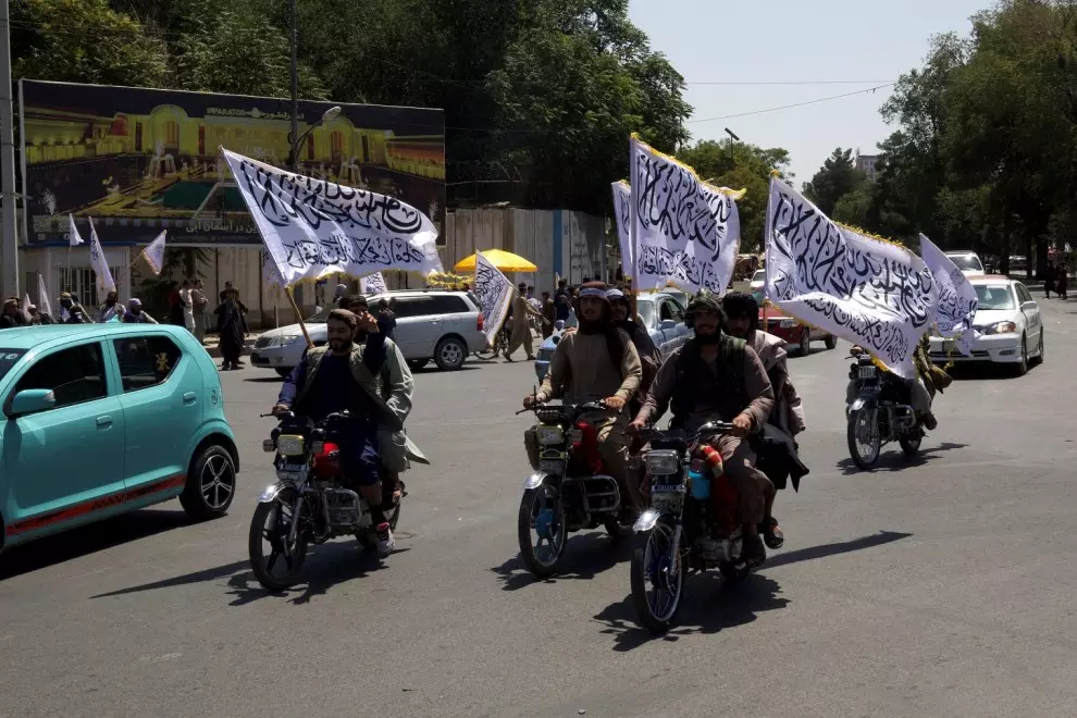 Varios talibanes montados en moto y con banderas participan en una marcha para conmemorar el tercer aniversario de la caída de Kabul y su llegada al poder en Afganistán. — Sayed Hassib / REUTERS